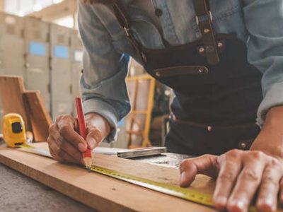 Carpenter working with equipment on wooden table in carpentry shop. woman works in a carpentry shop.
